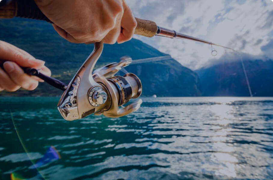 Person fishing with spinning reel on lake
