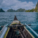 Outrigger boat heading toward tropical limestone islands